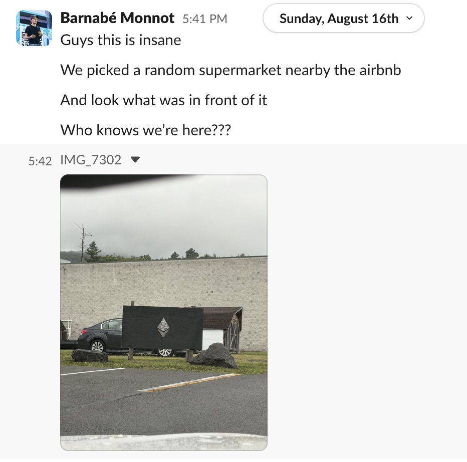 Slack messages from Barnabé Monnot with a photo of a black board bearing a carved Ethereum logo outside a supermarket: Guys this is insane. We picked a random supermarket nearby the airbnb. And look what was in front of it. Who knows we're here???